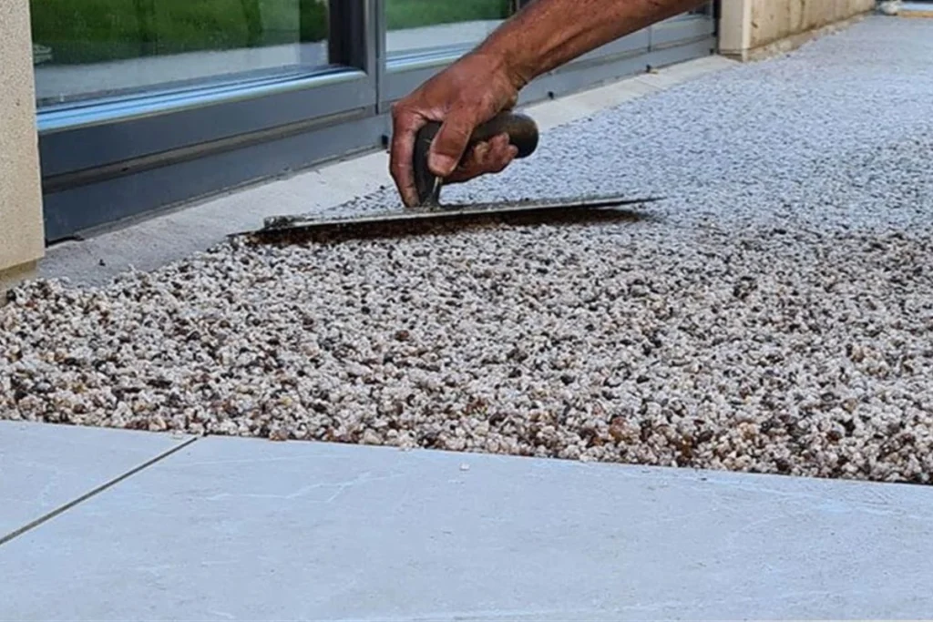 Sỏi Rải Sân Vườn: Cách Bố Trí Tạo Điểm Nhấn Độc Đáo Cho Không Gian 11 Bề mặt nền được rải sỏi hỗn hợp, gồm sỏi trắng, nâu, vàng và xám.