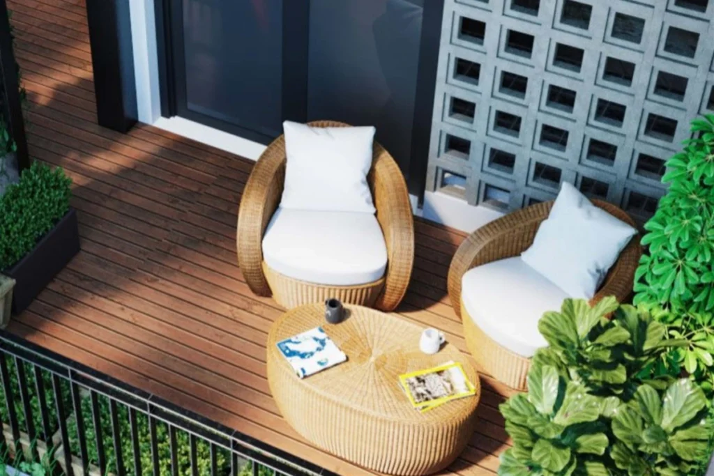 15 Ý Tưởng Decor Ban Công Đẹp Cho Cuộc Sống Thêm Chill 2 Bộ bàn trà mây nhựa nhỏ gọn cùng hai ghế thư giãn ngoài trời, đặt giữa không gian xanh mát và ánh nắng tự nhiên.