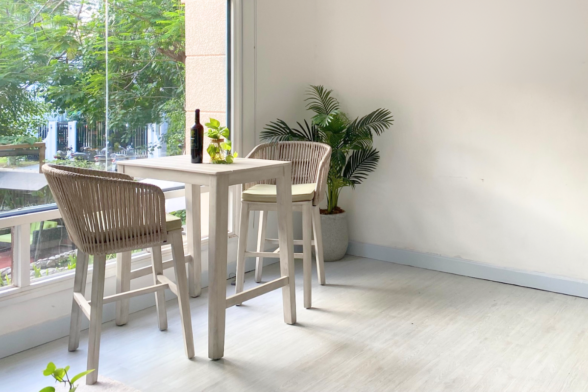 Phong Cách Minimalism: 3 Giải Pháp Ngoại Thất Tuyệt Vời Cho Không Gian Sống Tinh Gọn và Hiện Đại 5 Bộ bàn ghế cao hai chỗ ngồi đặt gần cửa sổ lớn, bên cạnh chậu cây xanh trong không gian sáng tự nhiên