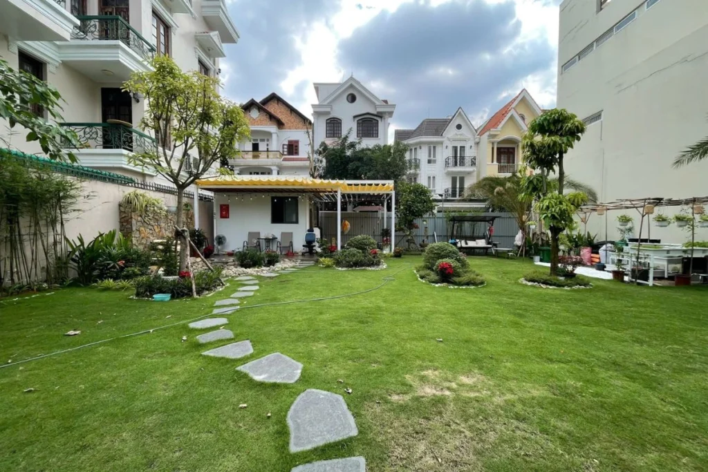 đồi cỏ xanh, đá lát sân vườn tạo lối đi, căn nhà nhỏ