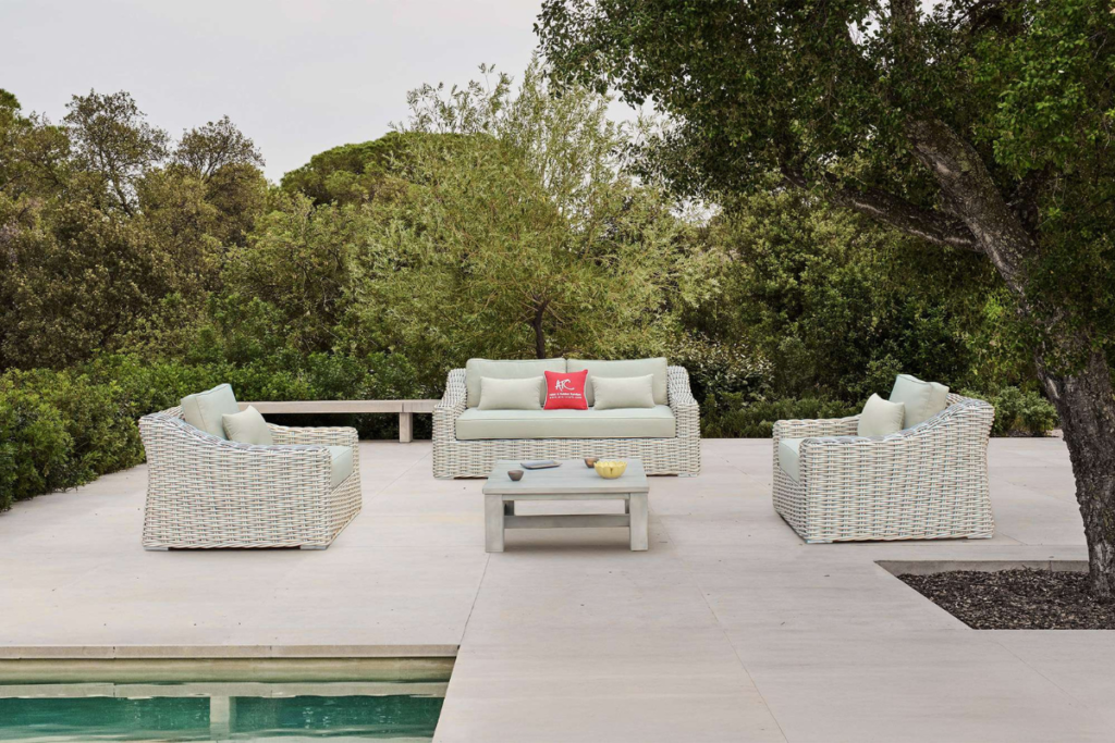 Bộ sofa mây nhựa KING bố trí ngoài trời với ghế ngồi sâu và đệm dày, tạo cảm giác thư giãn tối đa trong không gian xanh