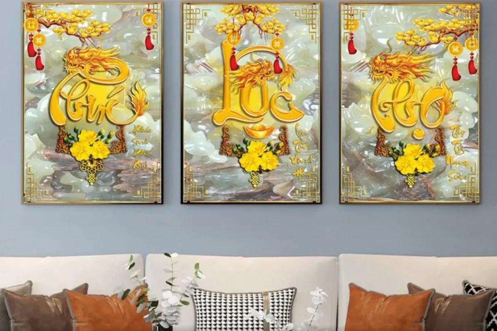 Bộ tranh dát vàng Phúc Lộc Thọ treo trang trọng trên tường phòng khách, nổi bật với sắc vàng sang trọng, biểu trưng cho phúc khí, tài lộc và trường thọ của gia chủ.