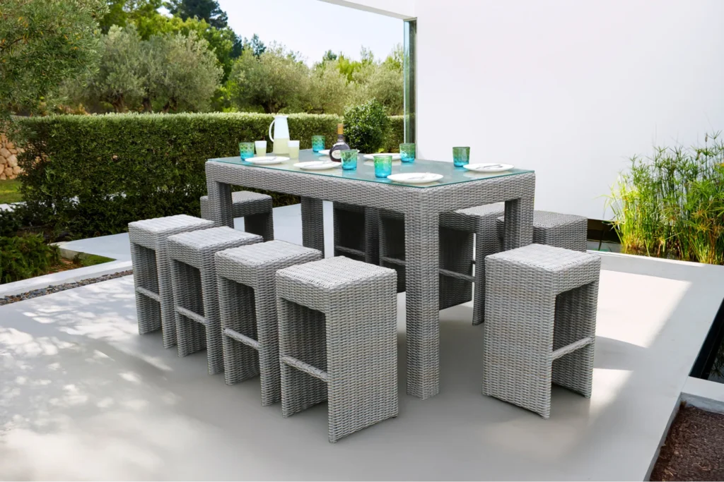 Bộ ghế quầy bar mây nhựa đặt ngoài trời, thiết kế dạng khối vuông, kết hợp bàn cao trong không gian sân vườn hiện đại.