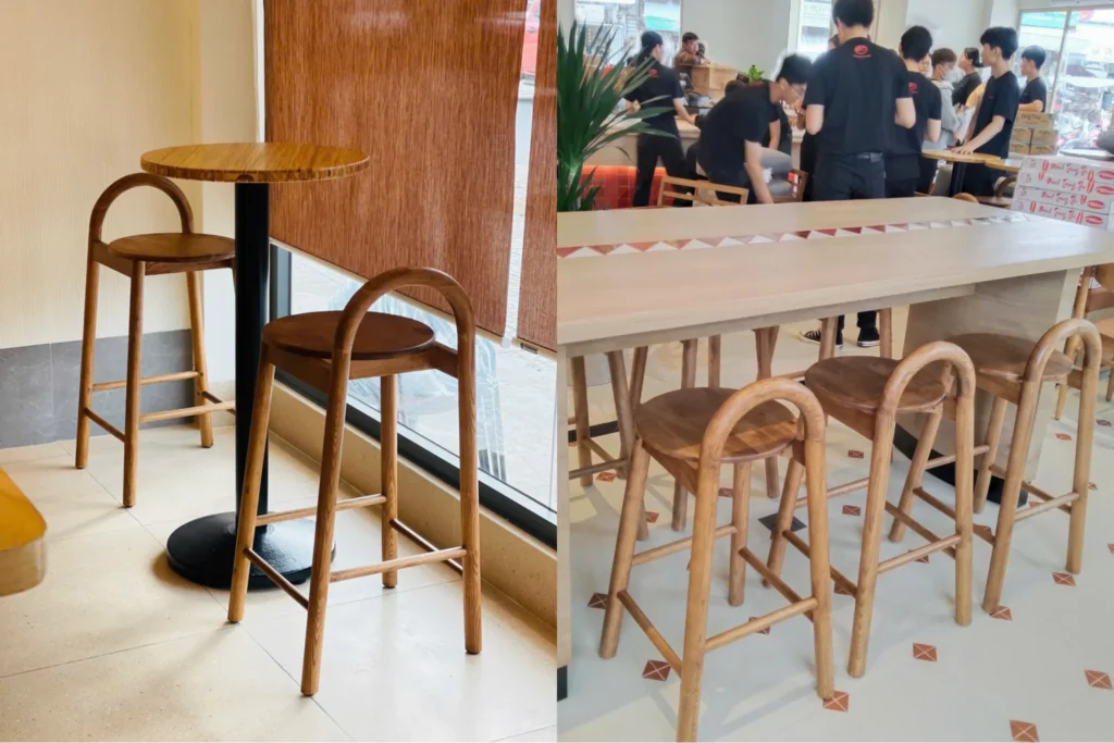 Ghế quầy bar gỗ đặt trong quán cà phê và nhà hàng, thiết kế chắc chắn, bố trí dọc theo quầy bar phục vụ không gian đông khách.