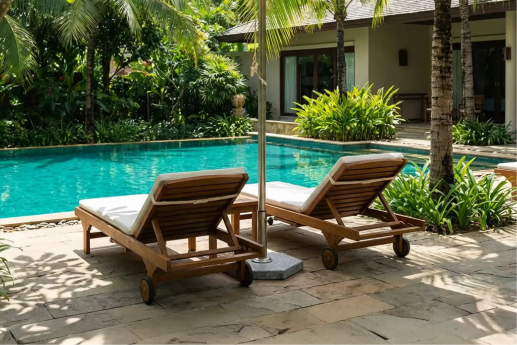 Hai ghế nằm gỗ lười đặt cạnh hồ bơi.