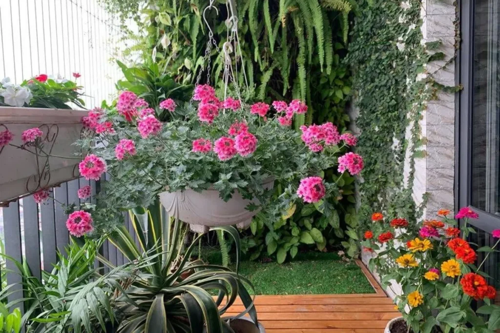 Top 10+ Cây Trang Trí Bồn Hoa Trước Nhà Đẹp, Dễ Chăm Và Hút Tài Lộc 3 Góc trước nhà với chậu hoa treo màu hồng và cây xanh bố trí gọn, giữ lối vào thoáng và tạo cảm giác chào đón