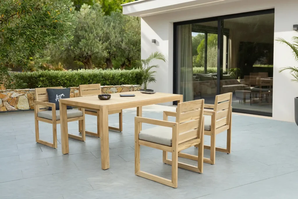 Bàn ghế gỗ teak ngoài trời đặt trong sân vườn hiện đại.