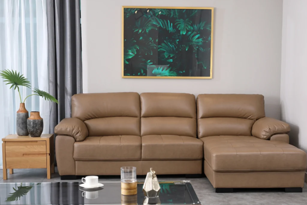 Sofa góc Index Living Mall màu nâu trong không gian phòng khách hiện đại với bàn kính và tranh treo tường